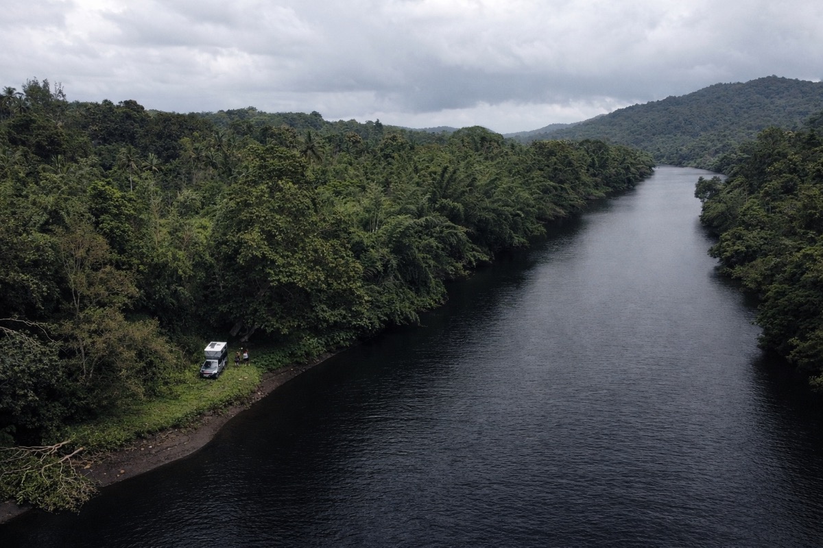 Campervan parked on the riverbank at Jungli, dense jungle on both sides of the Kali river