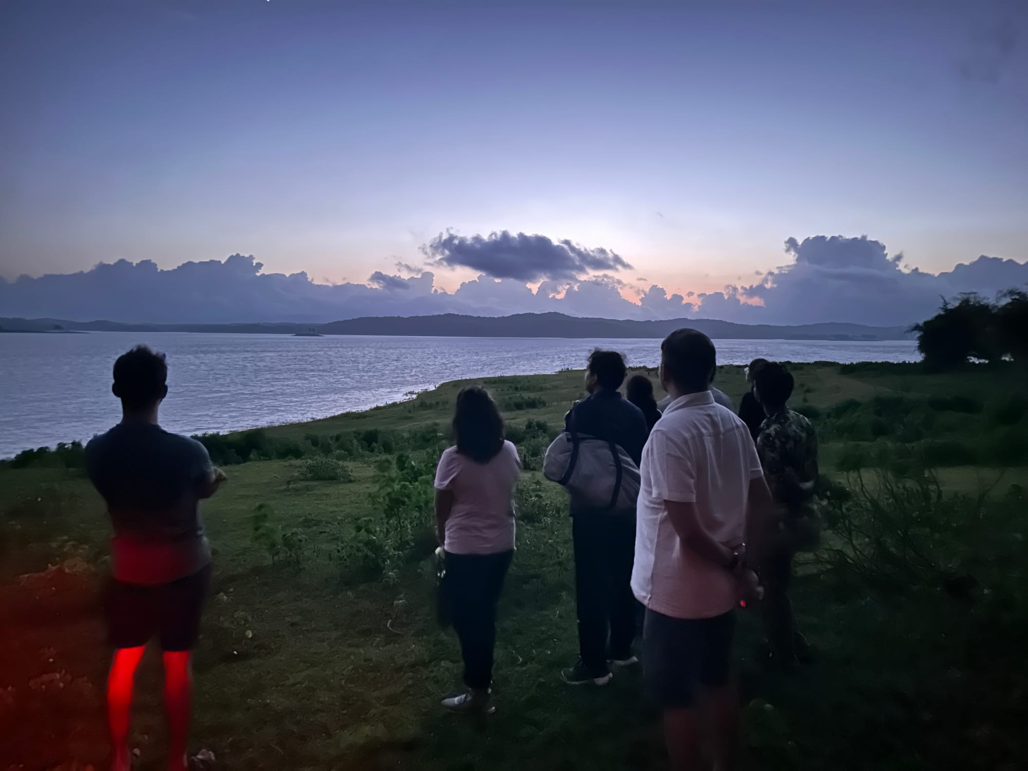Residents standing together watching the last sunset of the year over the backwaters