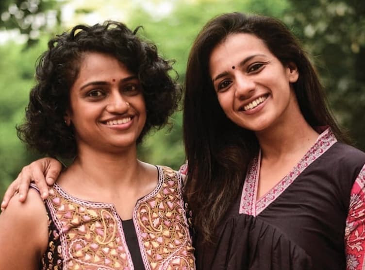 Sruthi Hariharan and Yashu, the two SAMA hosts, smiling together outdoors